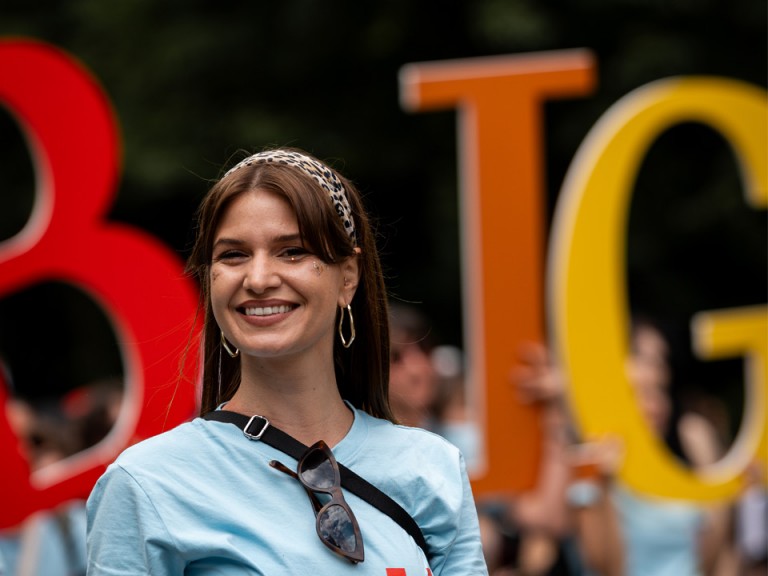 Giovane donna davanti a grandi lettere colorate